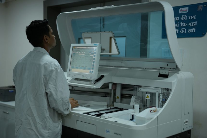 Técnico de laboratório opera um analisador clínico em um laboratório moderno.