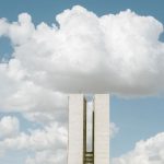Vista externa do Congresso Nacional, em Brasília, sob um céu parcialmente nublado.