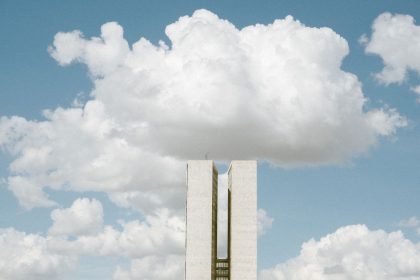 Vista externa do Congresso Nacional, em Brasília, sob um céu parcialmente nublado.