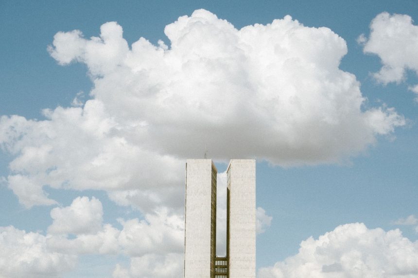 Vista externa do Congresso Nacional, em Brasília, sob um céu parcialmente nublado.