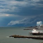 Vista aérea de uma tempestade se aproximando da costa de Mar del Plata, com nuvens carregadas sobre o mar e a orla.